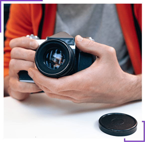 Person holding a camera lens, preparing to take a photo.